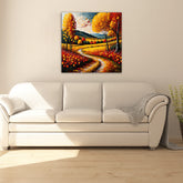 A canvas painting depicting a winding road with trees in autumn colors, displayed above a white sofa in a room with a light interior.