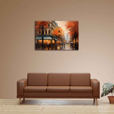 A canvas print depicting a colorful street scene with trees and a building, hung on a wall above a brown sofa.
