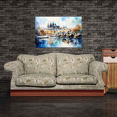 A canvas painting depicting a winter scene with a cityscape on a sofa against a brick wall background.