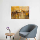 A abstract canvas painting featuring various shades of brown and yellow with geometric patterns, displayed on a wall above a grey chair and a small round table with a vase of flowers.