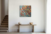 A canvas print featuring a colorful abstract tree pattern, displayed on a wall above a bench with a wooden frame.