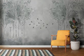 Yellow armchair in front of a wall with tree mural and birds