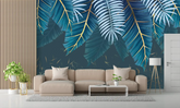 Living room with a beige sofa against a wall with tropical leaf pattern