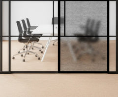 Modern office setup with glass walls, chairs, and a desk.