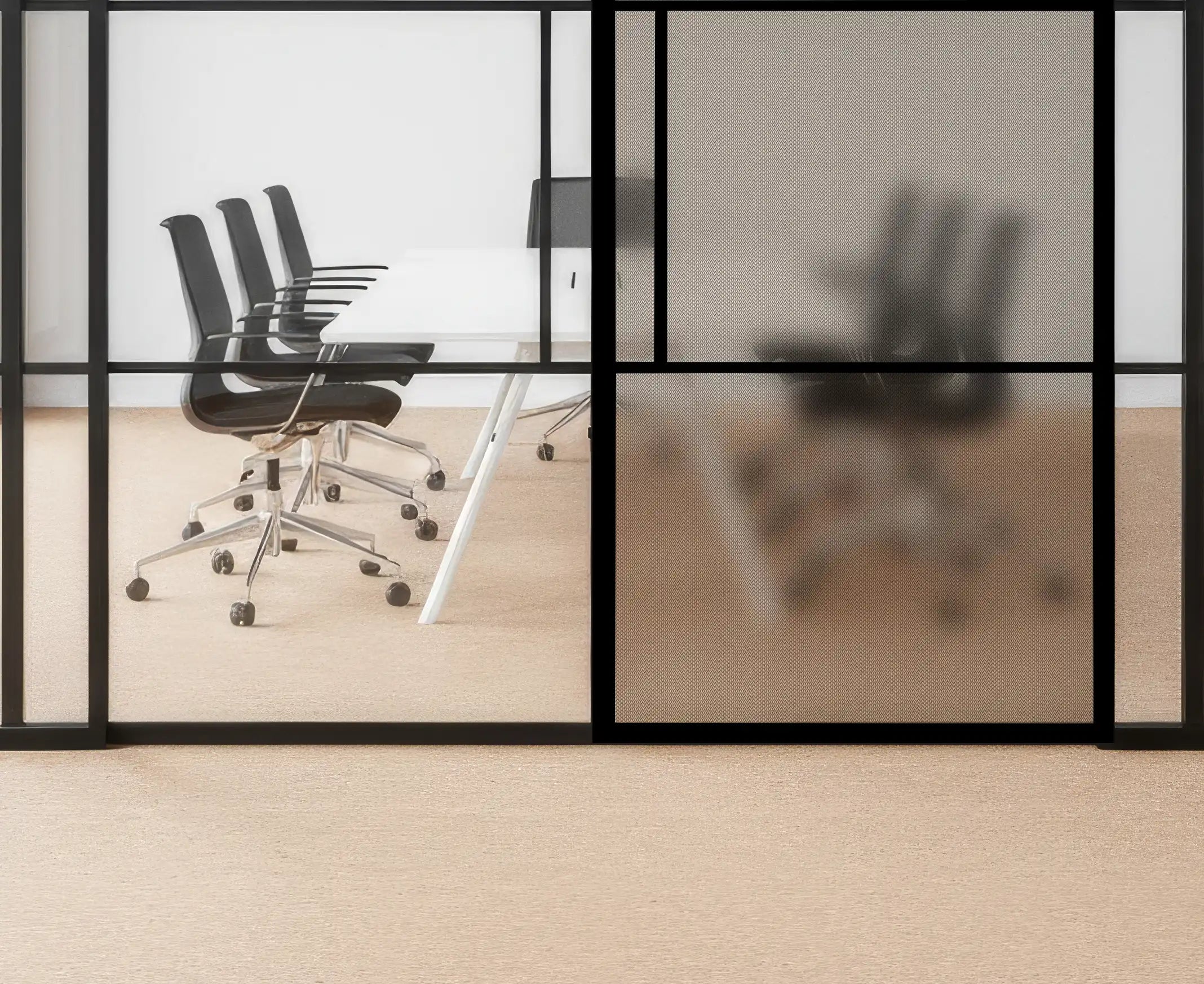 Modern office setting with glass walls and black chairs.