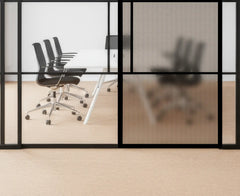 Modern office setting with glass walls and black chairs.