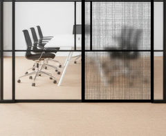 Modern office setting with glass walls, chairs, and a table.