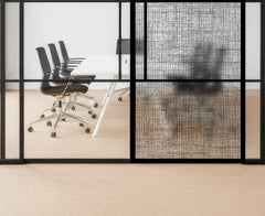 Modern office setting with glass walls, black chairs, and a white table.