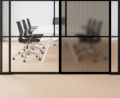 Modern office setting with glass walls, chairs, and a table.