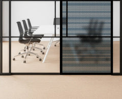 Modern office space with glass walls and black chairs.