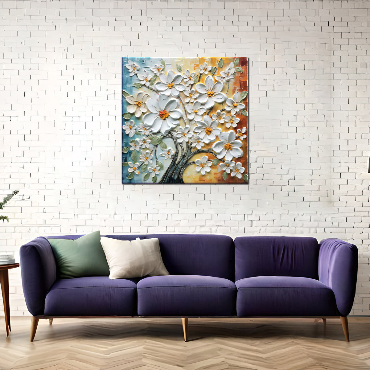 A framed abstract artwork featuring a tree with white flowers, displayed above a purple couch with a green pillow, in a room with white brick wall and a wooden floor.