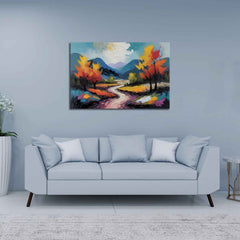A canvas print featuring a vibrant painting with a winding road, trees, and a mountain range in the background, displayed above a gray sofa in a room with a light blue wall.