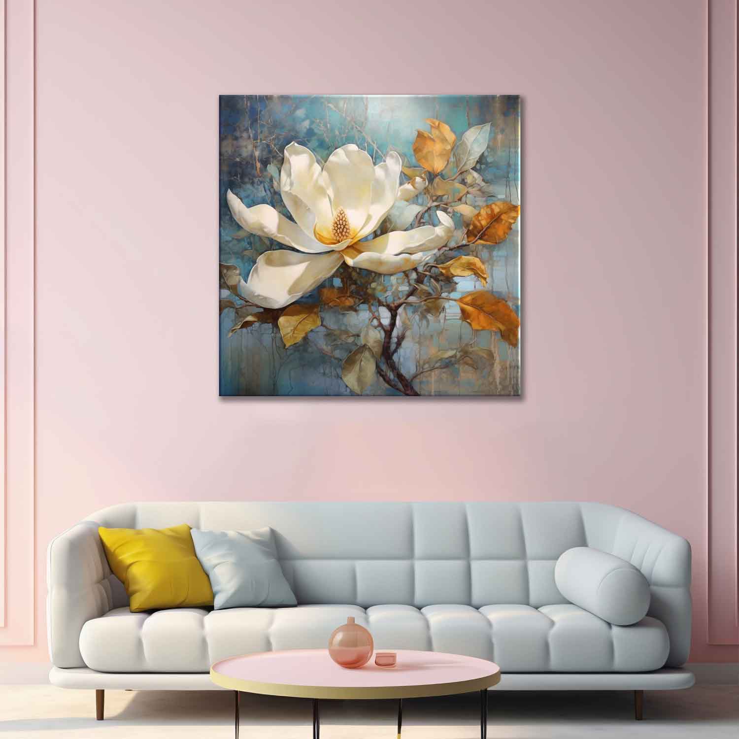 A canvas painting of a white magnolia flower on a branch, displayed above a white sofa with yellow cushions, against a pink wall.