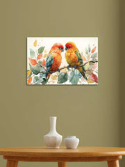 A canvas painting depicting two colorful birds perched on a branch, displayed on a wall above a table with a white vase and decorative items.