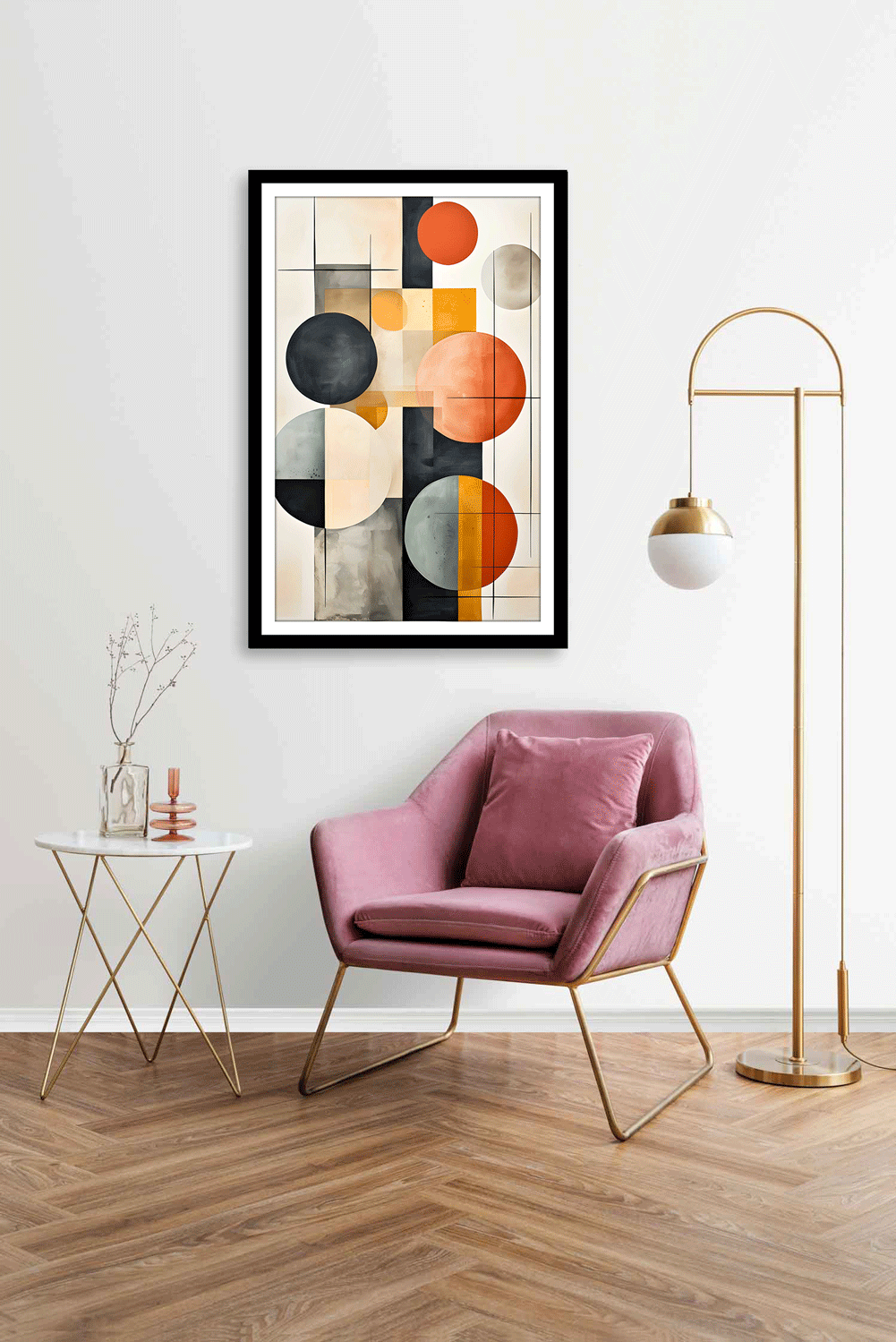 A modern geometric canvas painting featuring circles in black, white, gray, and orange, displayed in a room with a pink armchair.
