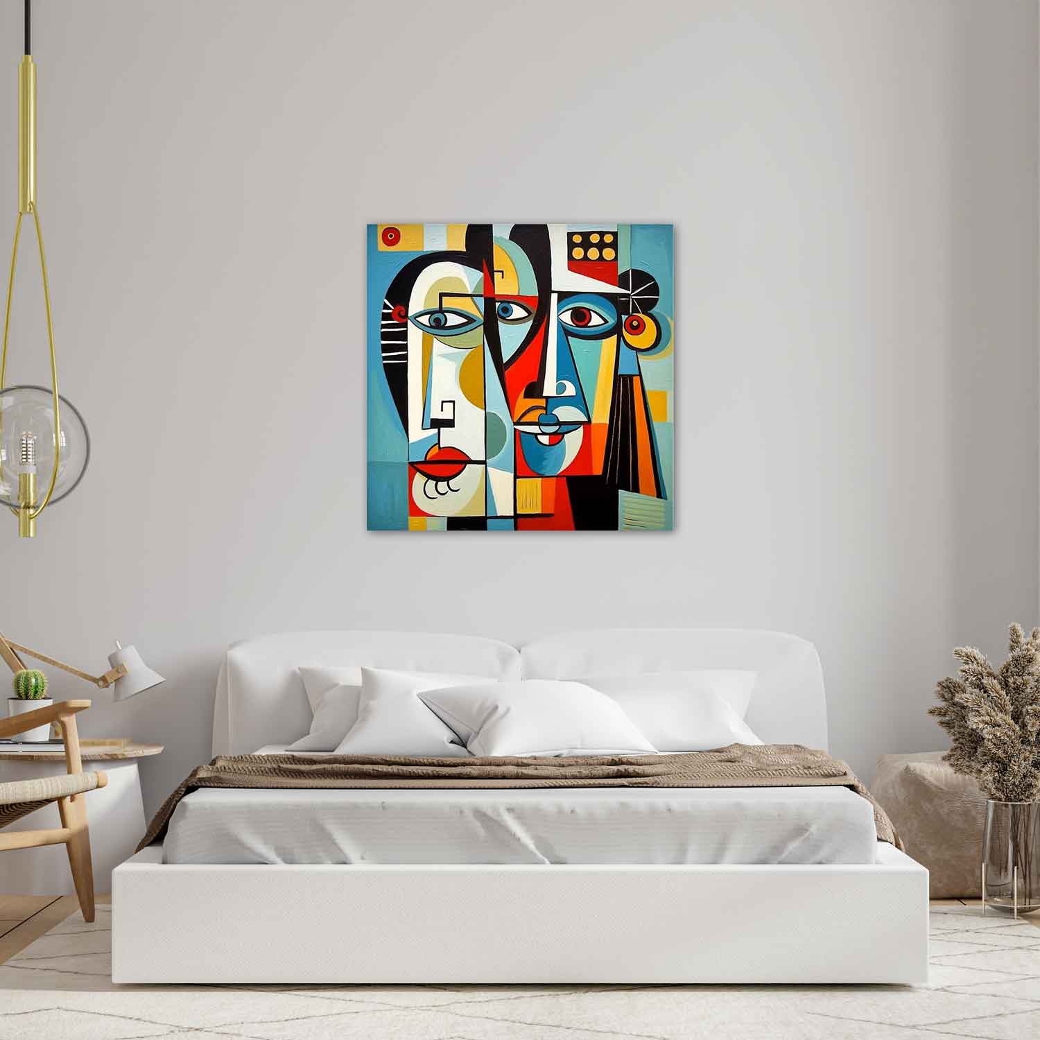 A colorful abstract painting featuring stylized faces with geometric shapes, displayed above a bed in a room with minimalist decor.