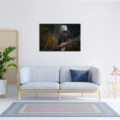 A canvas painting of an eagle perched on a branch, displayed above a grey sofa with a blue cushion, placed in a room with a wooden floor, a potted plant to the side, and a decorative wall piece to the right.