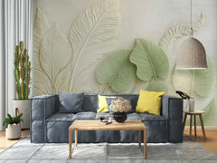 Living room with a blue sofa, yellow pillows, and decorative leaf wall art.