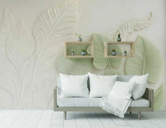 Living room with a sofa, decorative pillows, and wall art featuring large green leaves.