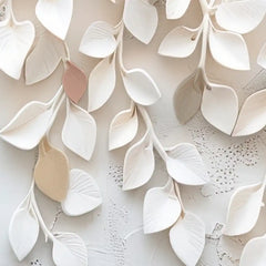 Close-up of white ceramic leaves on a textured white background