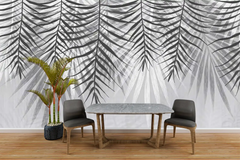 Dining area with a marble table and chairs against a wall with palm leaf pattern